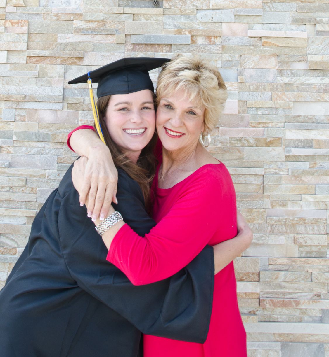 A college grad hugging her grandma.